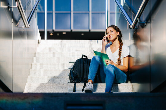 Friendly blonde college student talking on her phone with some friend