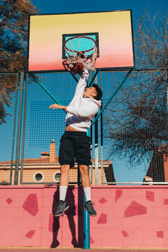 Yung man jumping and playing basketball