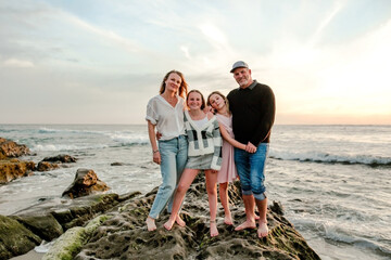 Family with two tween daughters spending evening at beach 