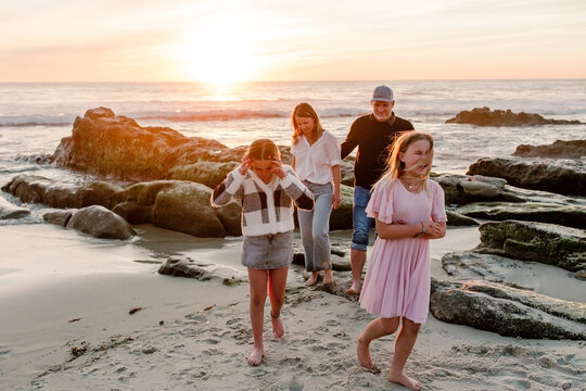 Smiling family hugging at the beach