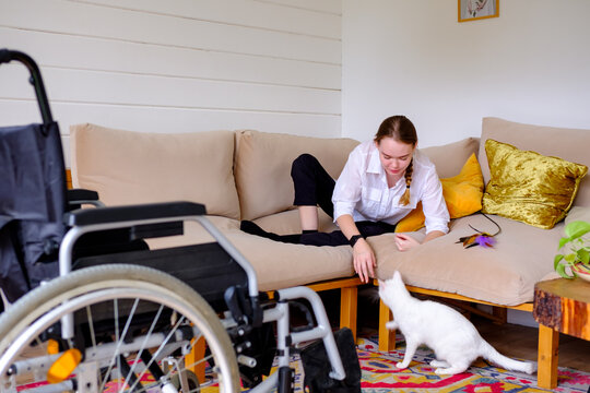 woman with a disability playing with cat 