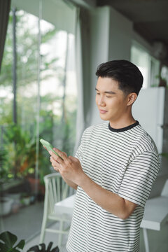 Smiling businessman holding using cell phone mobile apps standing