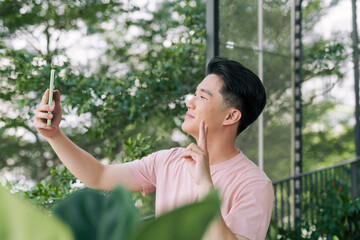 Handsome young man taking a self portrait outdoor at balcony.