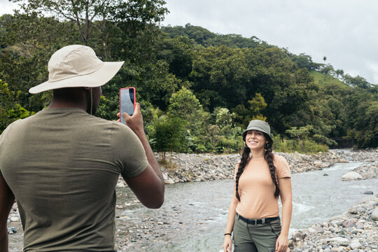 Traveling friends taking photos with smartphone in the jungle