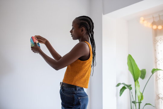 Black painter examining palette and choosing color