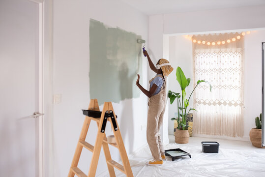 Black female dancing and painting wall