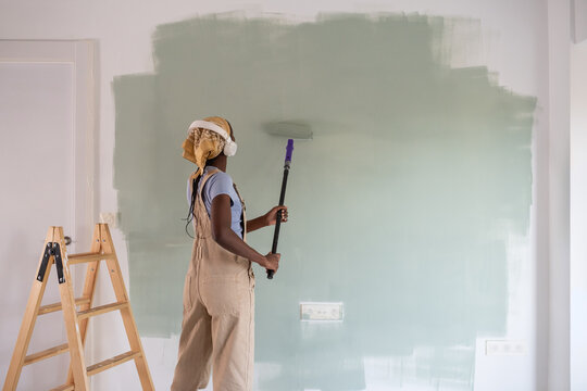 Black painter listening to music during renovation