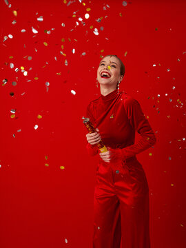 Happy woman with confetti on a red background