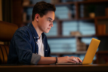 Concentrated young guy developer typing on pc keyboard, coding