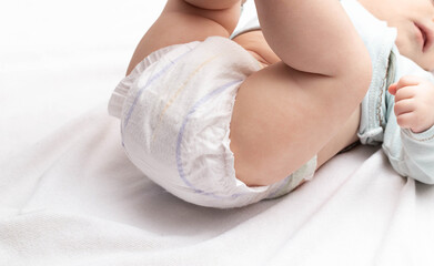 Soft and comfortable diaper for the baby who lies on the bed. Copy space for text - obrazy, fototapety, plakaty