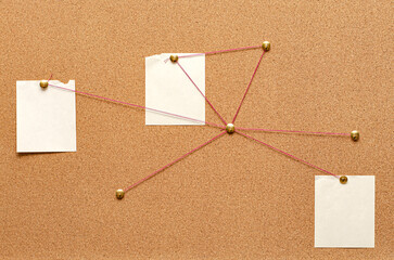 Blank paper notes are pinned to a cork board. The concept of detective investigation. Copy space.