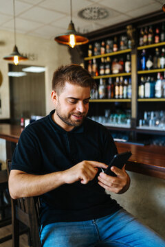 Man browsing cellphone in pub