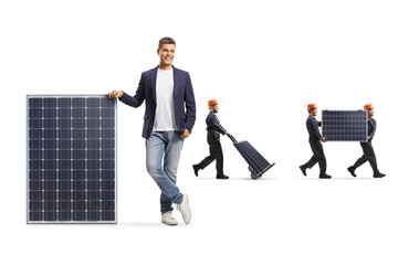 Man leaning on a solar panel and factory workers transporting panels