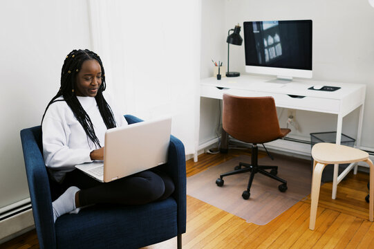 smiling black woman working in home office on her laptop