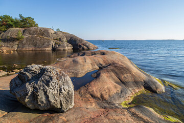Fototapeta premium Beautiful rock, rocky coastline and shoreline cliffs at Puistovuori in Hanko, Finland, on a sunny day in the summer.