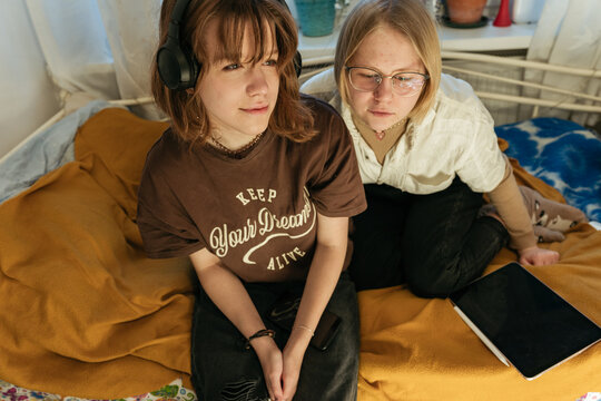 Two teenager friends listening to music together