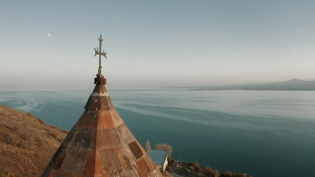 The dome of Surp Astvatsatsin church in Sevanavank monastic complex and Sevan lake behind