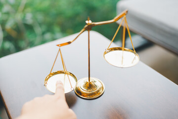 Tip the scales of justice concept as a the hand of a person illegally influencing the legal system...