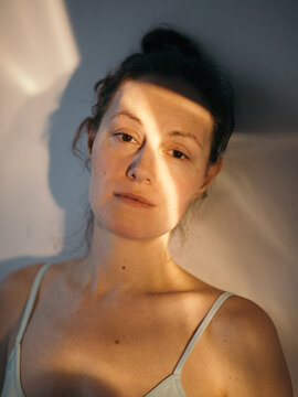 Calm woman looking at camera portrait in sunlight