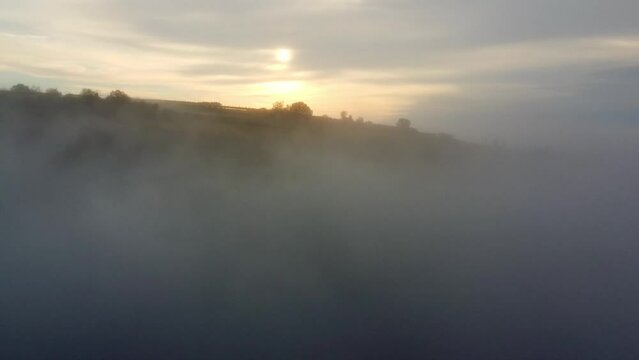 Aerial of the hills covered in the fog in Soave, Verona, Italy with the cloudy sky on background