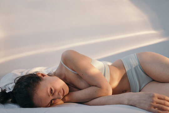 Depressed woman lying on bed