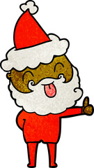 man with beard sticking out tongue wearing santa hat
