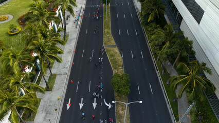 Honolulu Marathon, people running on a street in the city, Aerial top-down drone view.