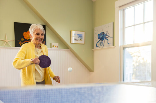 Active Senior Citizen lifestyle woman playing ping pong with skill 