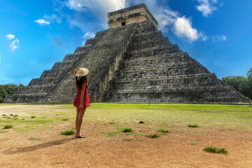 Sexy tourist enjoying the sun rays of the pyramid of Chichen Itza in Mexico, the famous castle and temple of the Mayan civilization and culture.