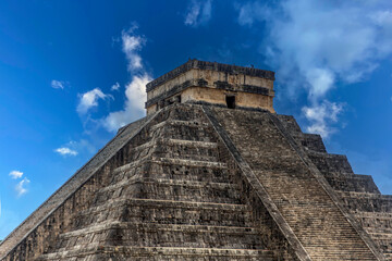 The pyramid of Chichen Itza in honor of the God Kukulkan under a beautiful tropical blue sky, this is the feathered serpent and the castle of the Mayan civilization.