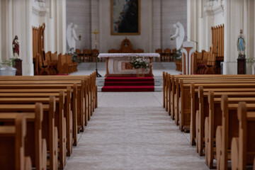 Fototapeta na wymiar Horizontal image of empty old church with altar and wooden seats for different ceremonies