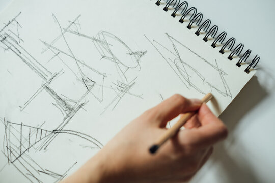 Cropped Image of Woman Sketching A House 