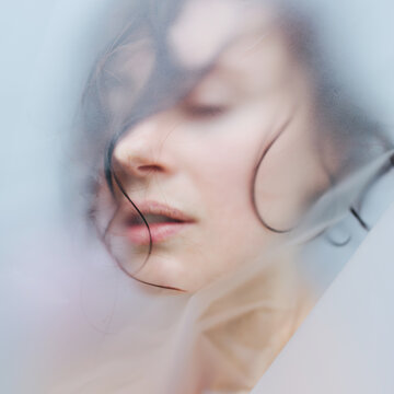 Face of woman through matte glass