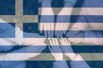 Hands of kids on background of Greece flag. Greek patriotism and unity concept.