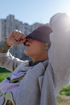 Hipster woman covering half of her face pulling down her hat