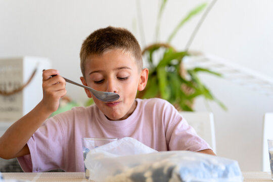 Child eating cereal and milk for breakfast