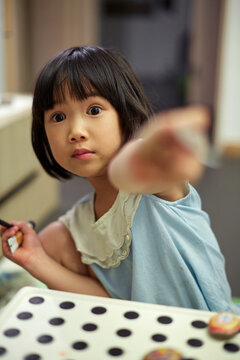 Asian girl draw mandala pattern on stone, at home