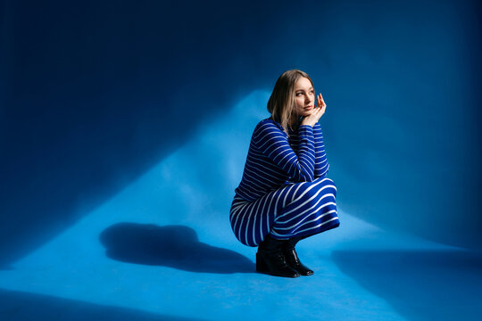 Pensive woman leaning head on hands in studio