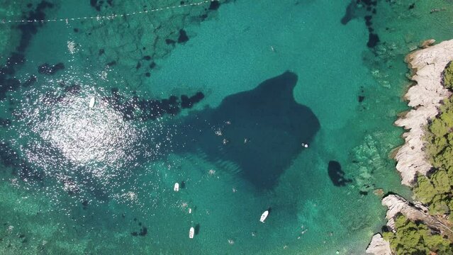 Aerial video of boats, yacht, docked in harbor tropical clear green water sea.
