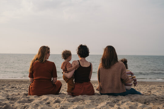 Group of mothers sitting on the beach
