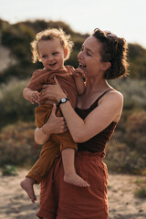 Obraz premium Mother holding her little son on the beach