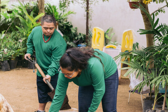 Man and woman cleaning the garden with shovels.
