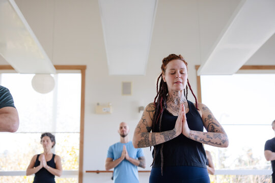 Meditative group yoga class practice inside modern studio.