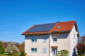 Mehrfamilienwohnhaus mit Solardach vor blauem Himmel