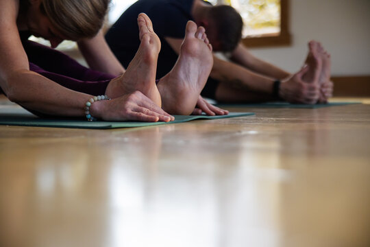 Feet and hands during hamstring stetch in yoga class.