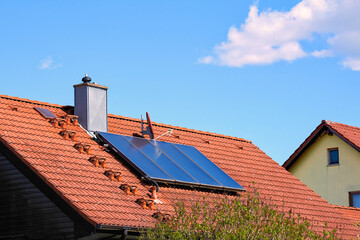 Rotes Hausdach mit Solarthermieanlage