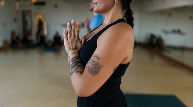 Meditative group yoga class practice inside modern studio.