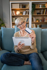 Senior woman caucasian female hold credit card online shopping at home