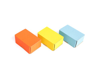 Colored craft boxes on a white background. Orange, blue, yellow. Place for text and logo. The concept of packaging, holiday, gifts. High quality photo