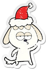 distressed sticker cartoon of a bored dog wearing santa hat